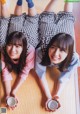 Two young women laying on the floor holding cups of coffee.