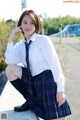 A woman in a school uniform is posing for a picture.