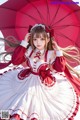 A woman in a red and white dress holding an umbrella.