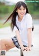 A young woman sitting on a bench with her legs crossed.