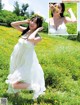 A woman in a white dress standing in a field of flowers.