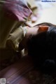 A little girl laying on a bed with her head in her hands.