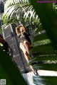 A woman in fishnet stockings laying on a metal fence.